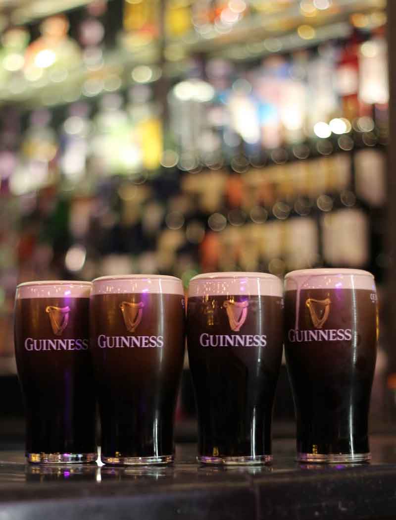 Fresh pints of Guinness lined up on the bar at The Market Bar, ready for the Six Nations match.